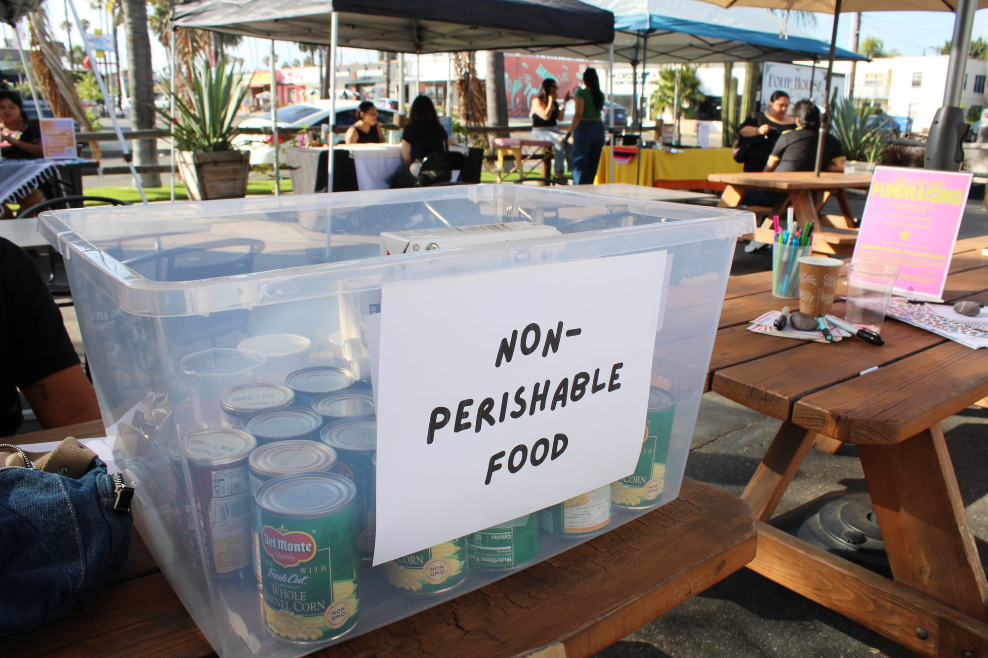 A container with the label non-perishable food holds corn and other canned goods