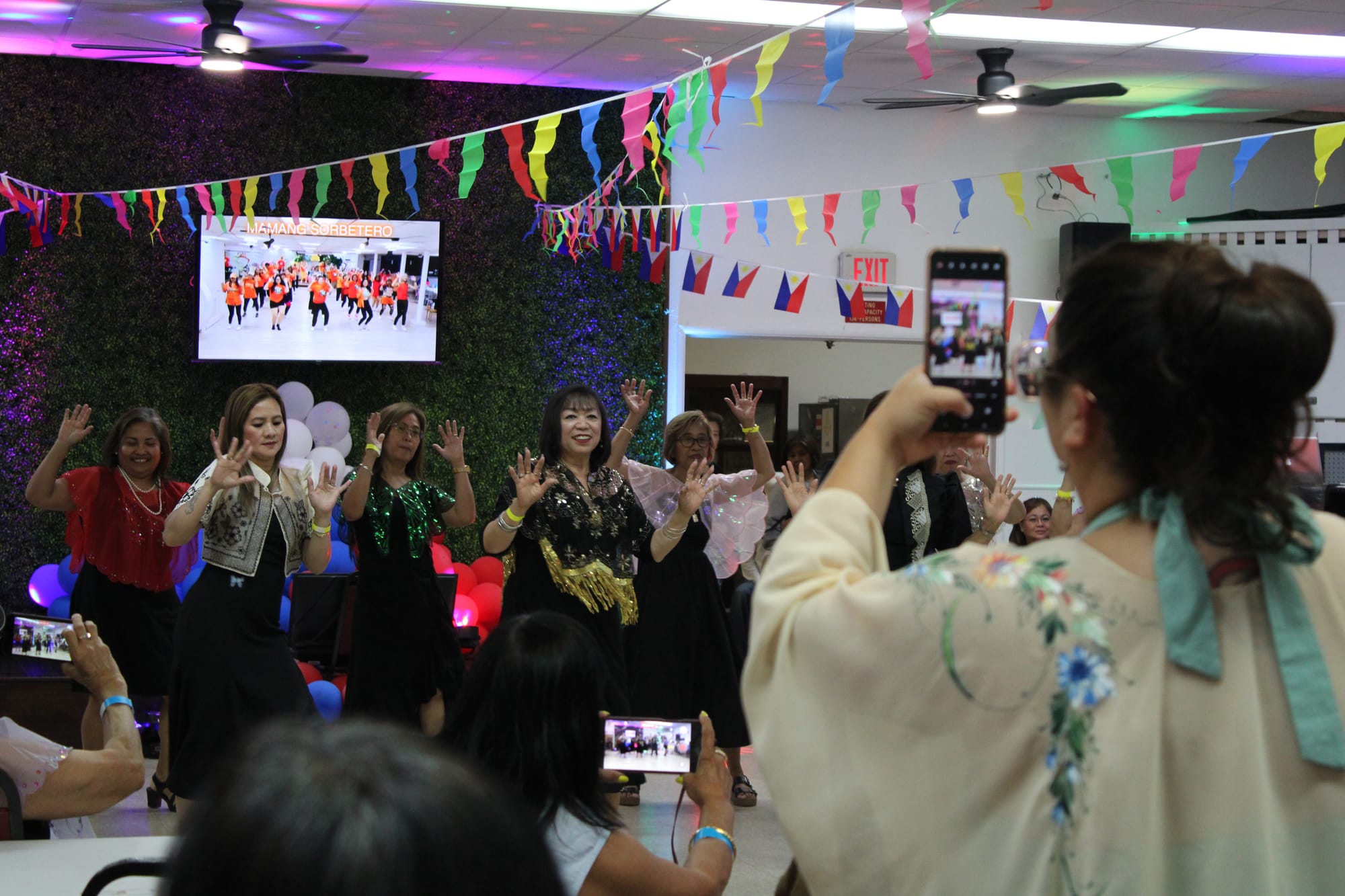 A group of people dance in a hall