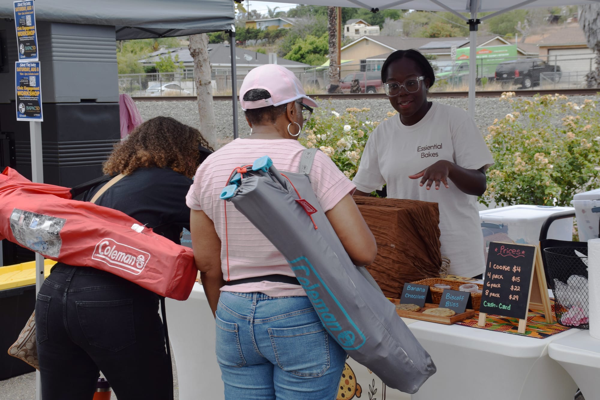 A woman talks to customers at her vendor booth