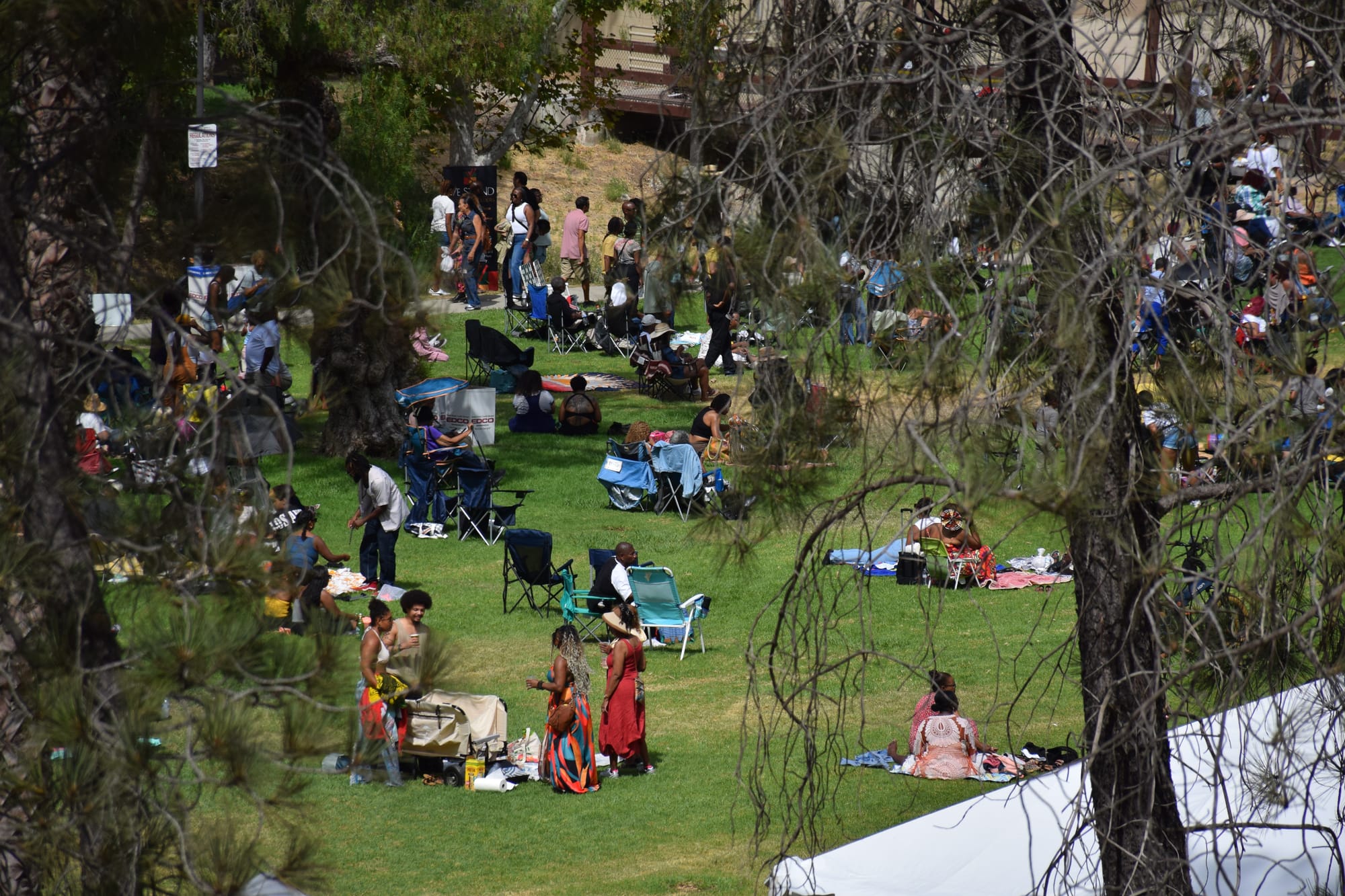 People hang out on picnic blankets and camping chairs