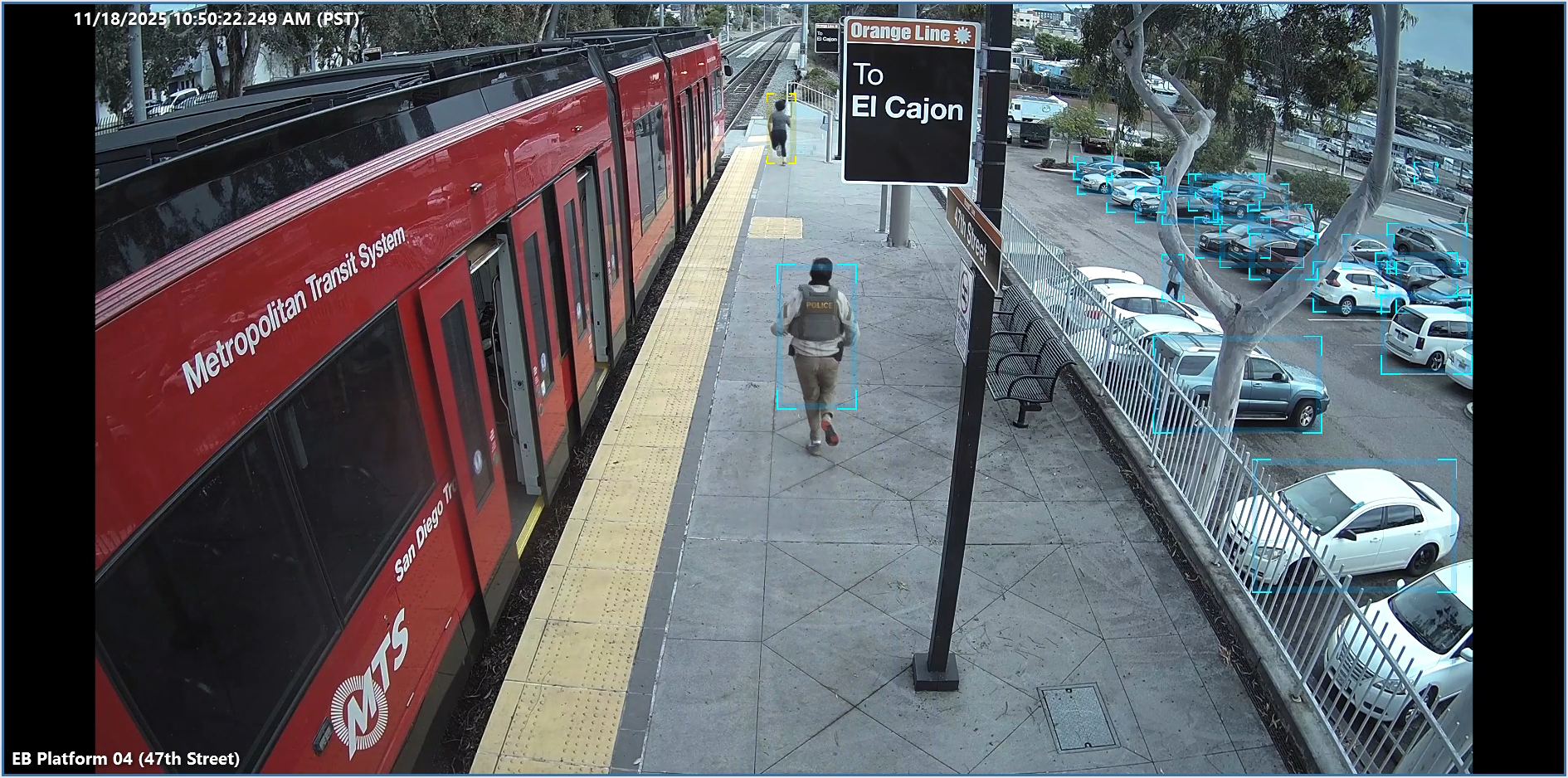 A man runs with his back to the camera next to a red trolley