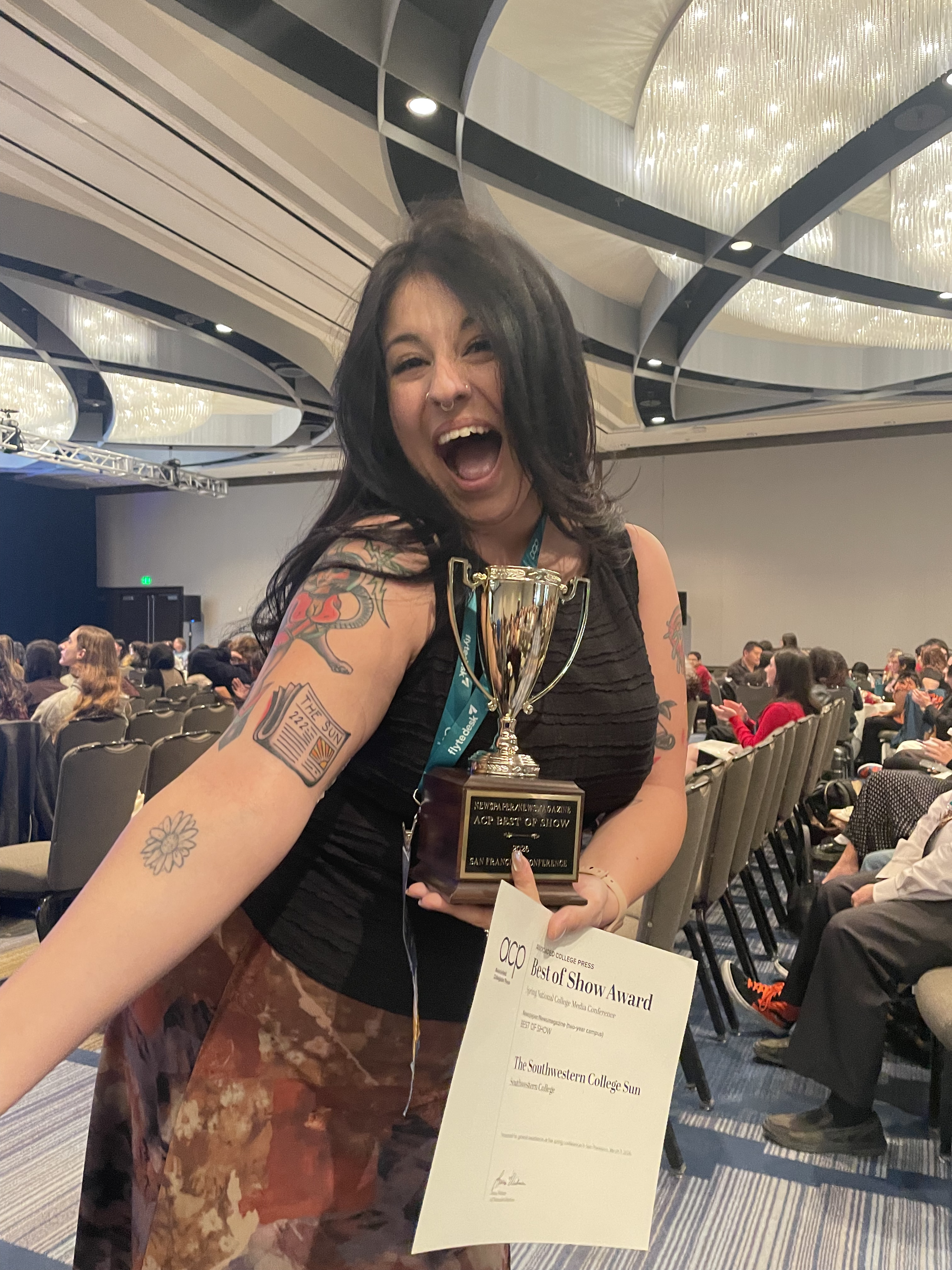 A person holds a trophy and a paper award