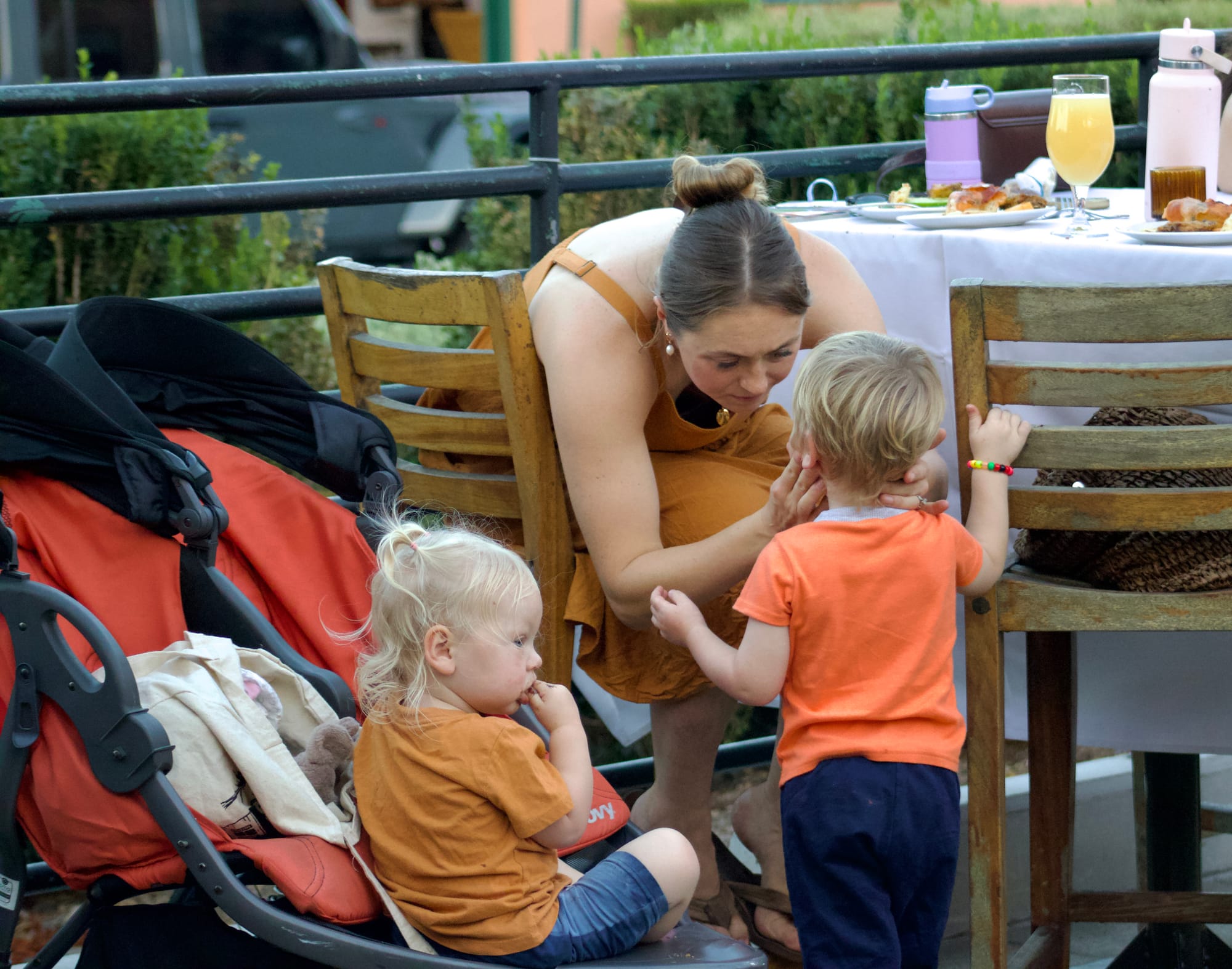 A woman holds her child's face at an outdoor event at a restaurant.