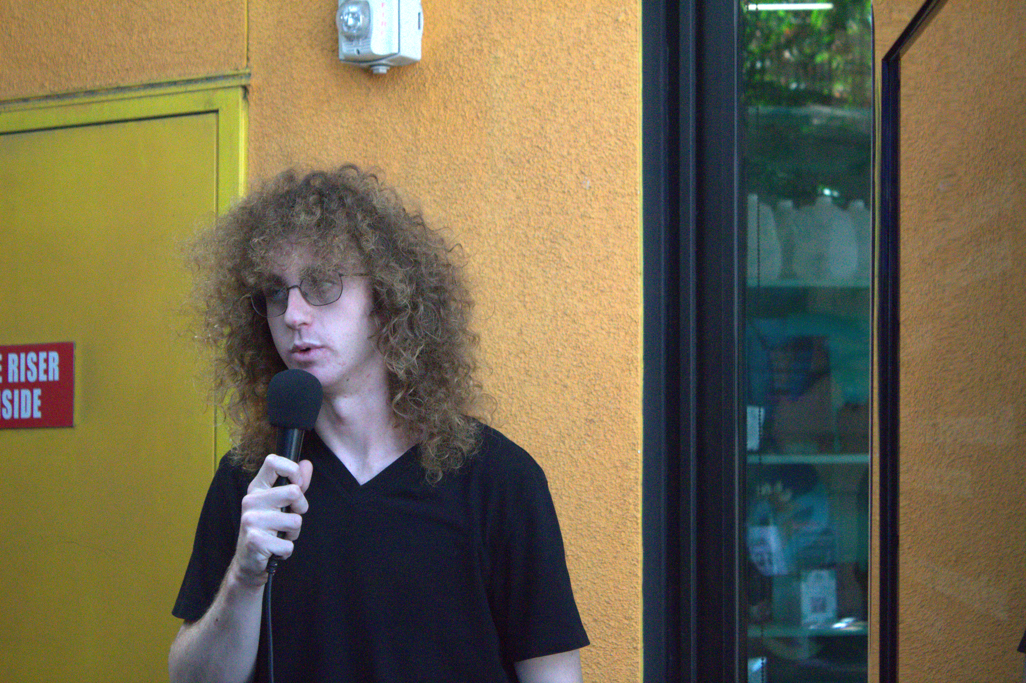 A man holds a mic while speaking.