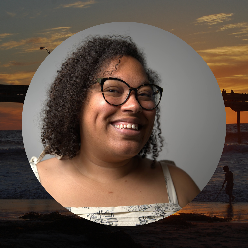 a headshot of a woman with curly, dark hair