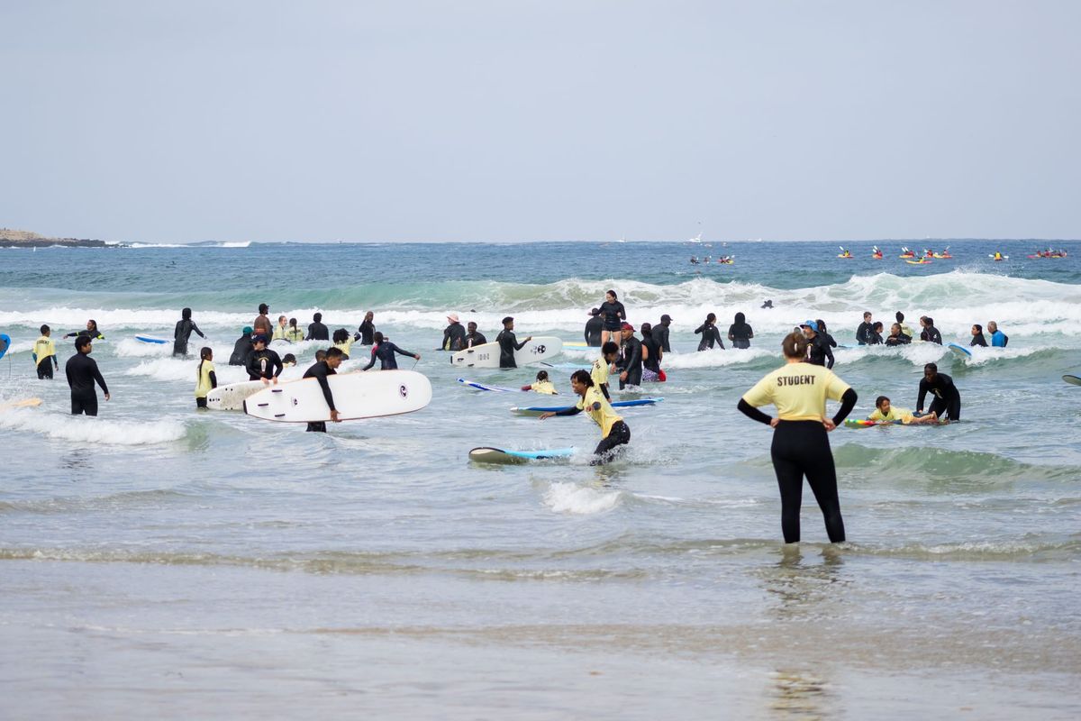 Surf students play in the shallow water at the beach