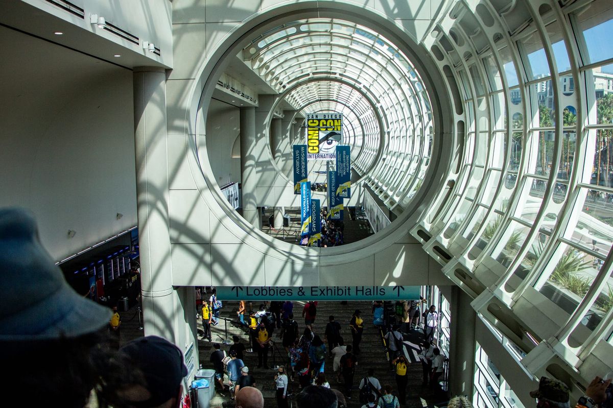 Picture of a convention hall with a comic-con poster in the back