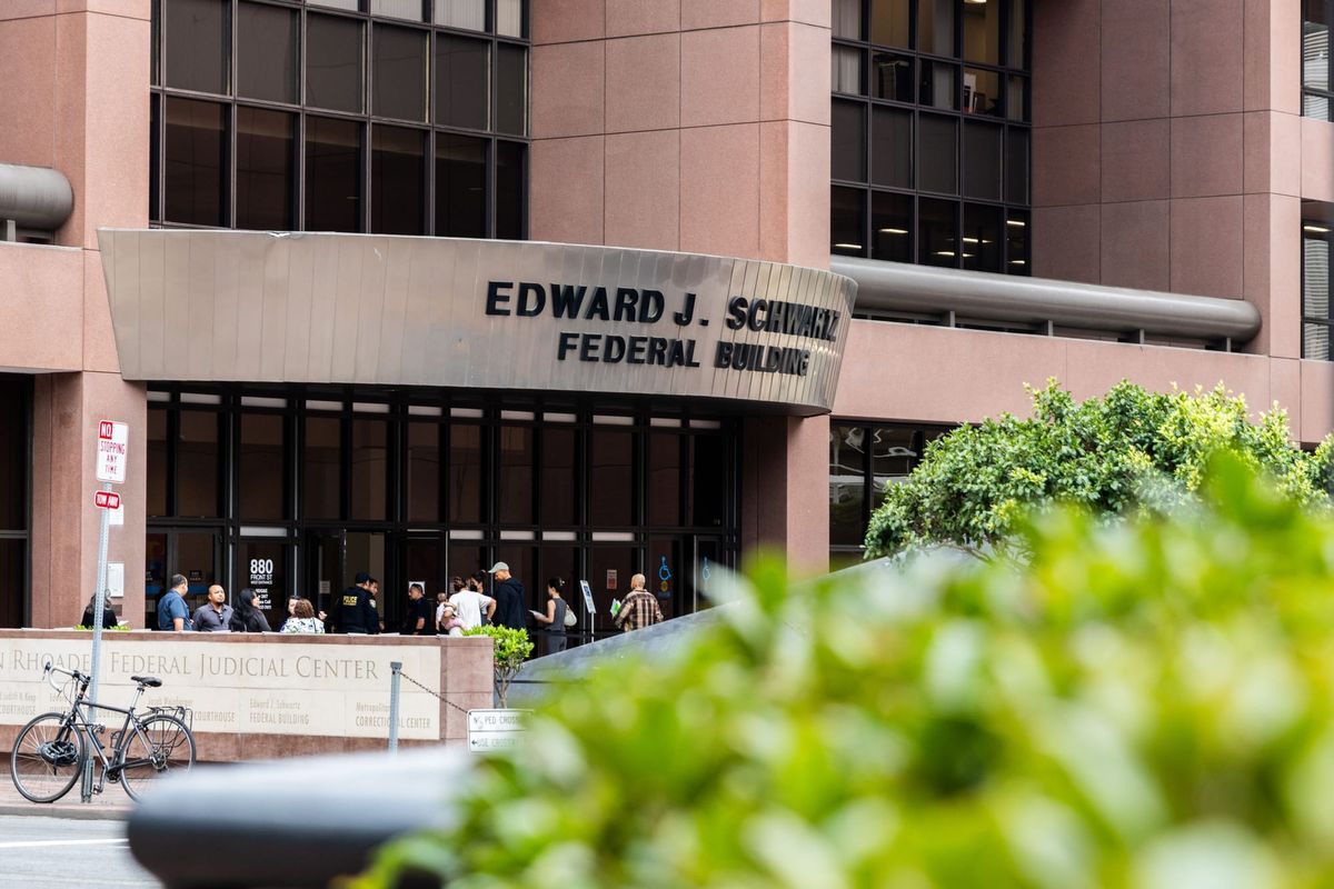 picture of a building with a bush and trees in front of it.