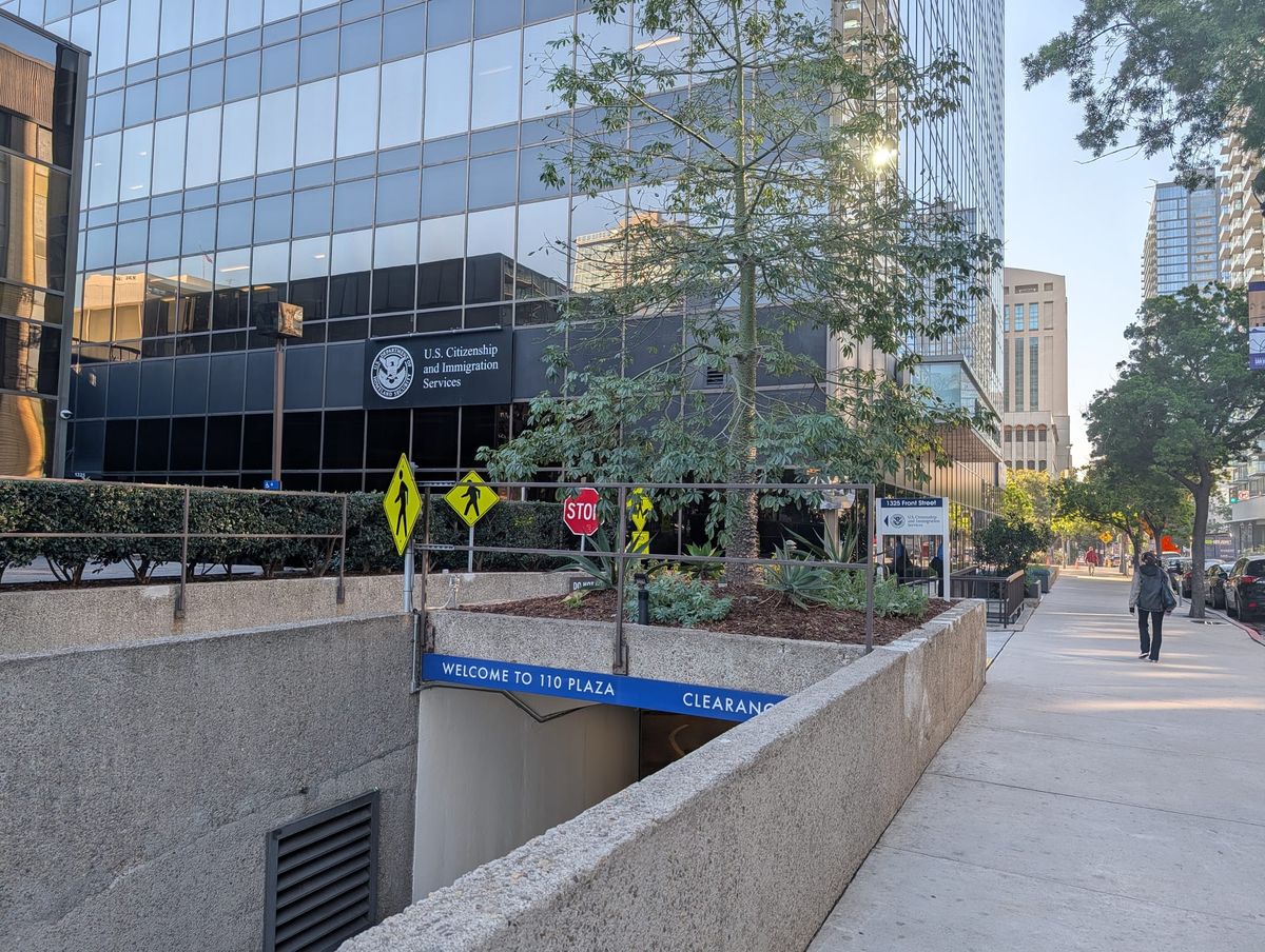 Picture of buildings, one with a sign that says "U.S. Citizenship and Immigration Services" on it.