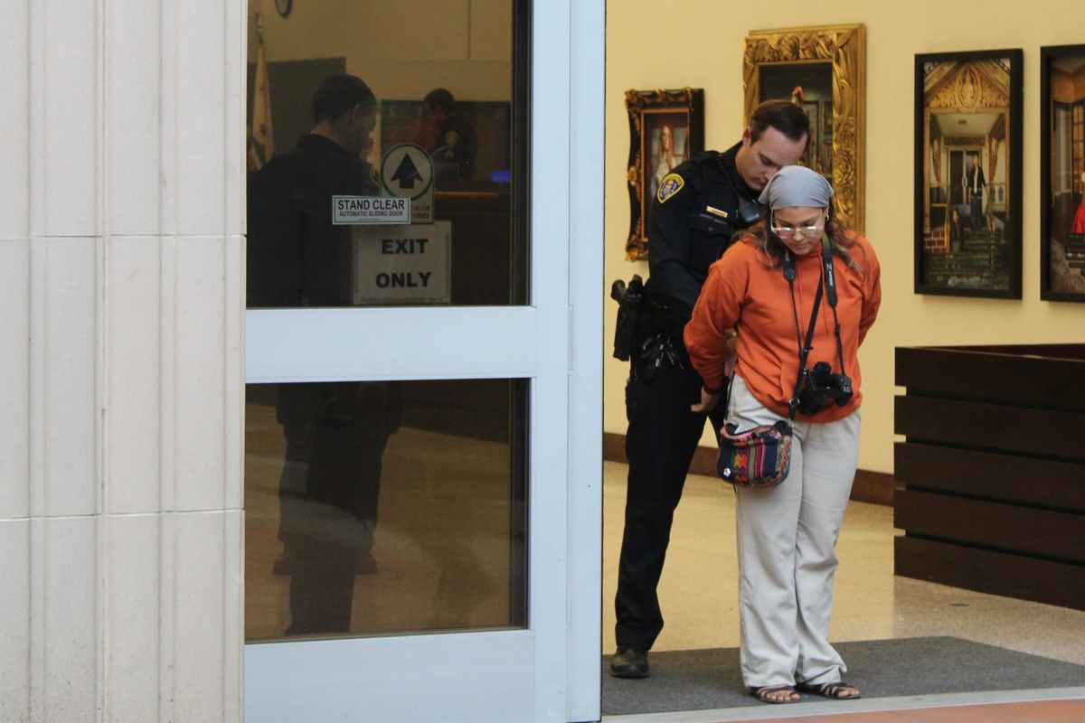 A police officer removes handcuffs from someone at the entry to a building.