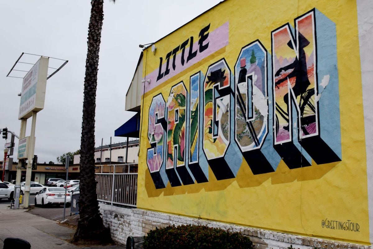 A photo of a mural with a yellow mural that says "Little saigon" with colorful images painted within each letter