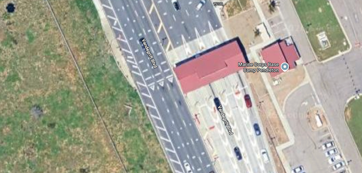 A bird's eye view of a guardhouse at the end of several car lanes