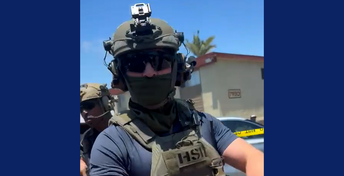 A man with a green helmet and dark face mask and sunglasses 