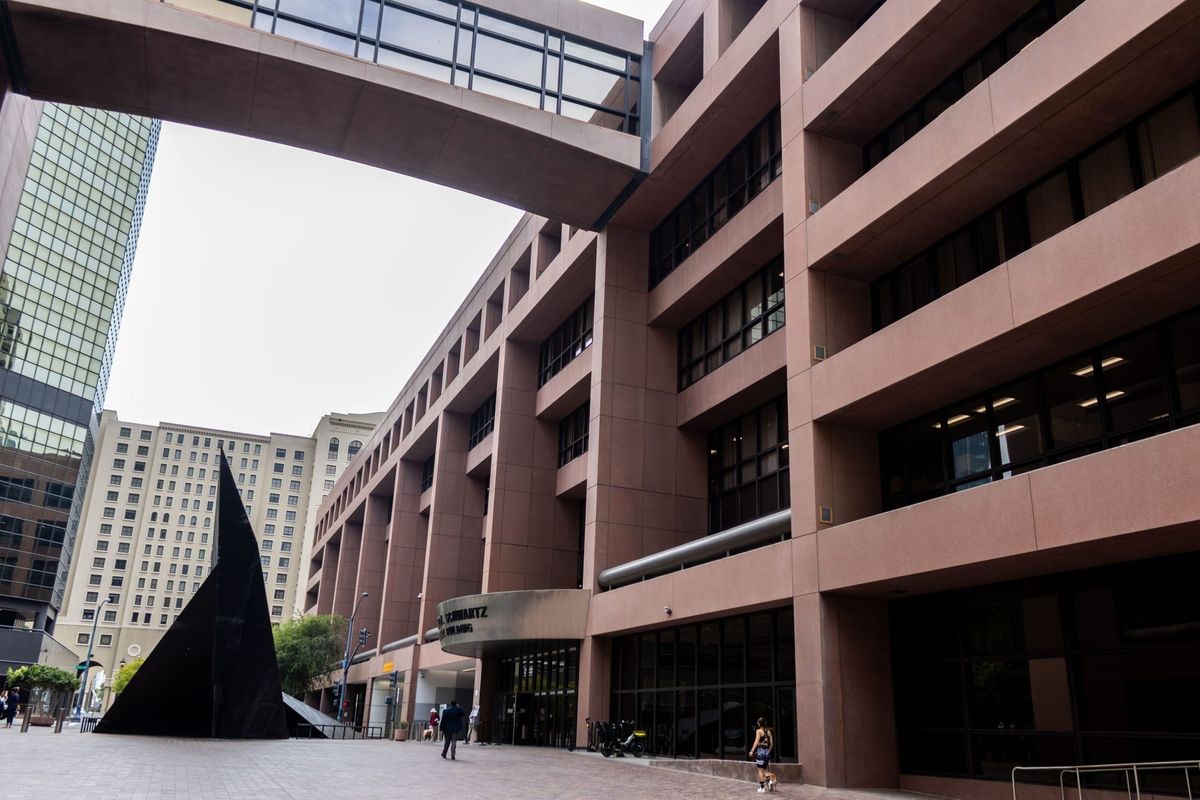 A brown building with a brick plaza in front