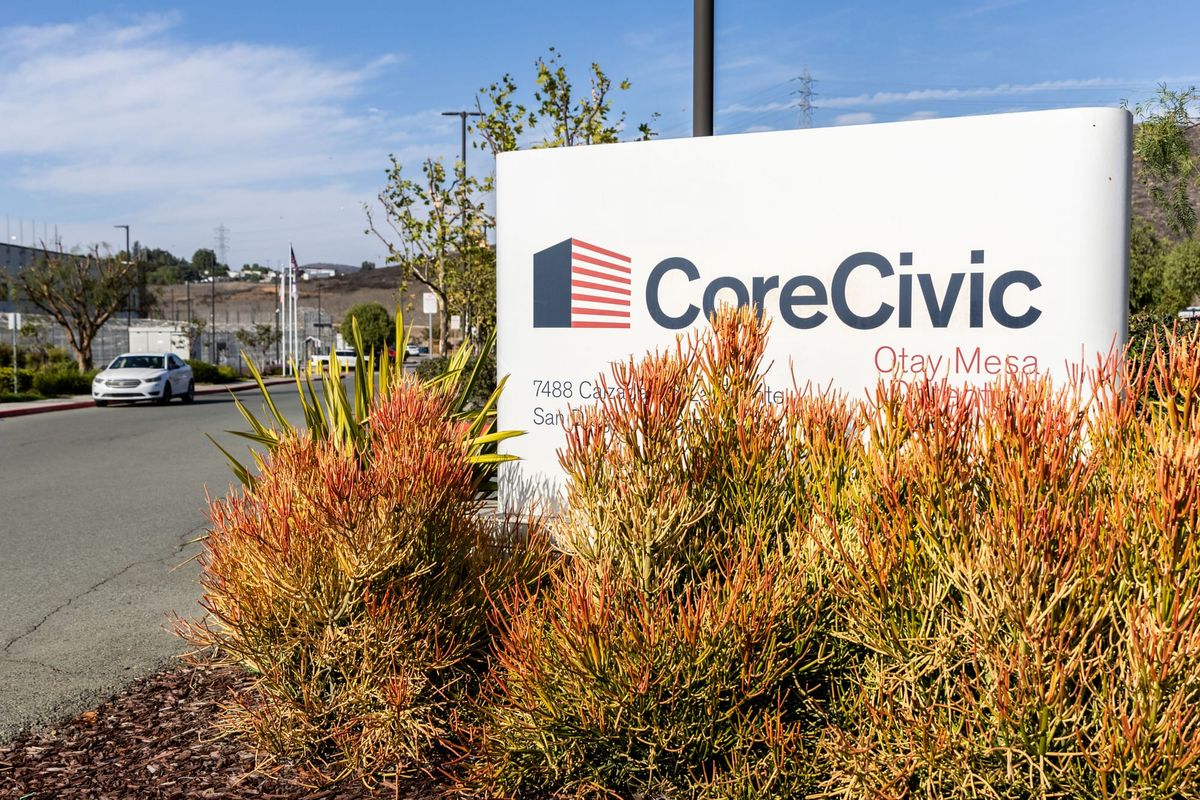 A sign that says CoreCivic next to a prison building