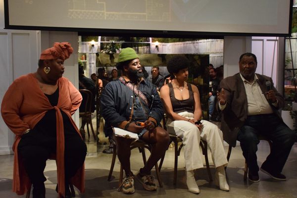 Four people sit in chairs in a line