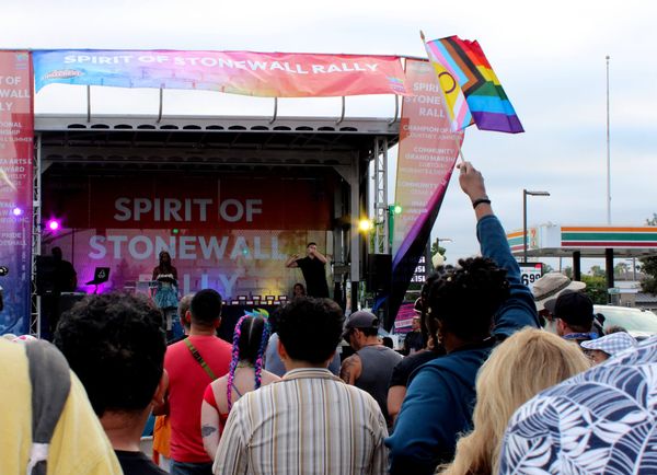 a crowd of people watch a performance on an outdoor stage