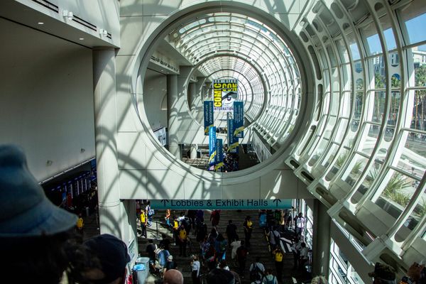 Picture of a convention hall with a comic-con poster in the back