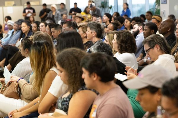 People sit in a crowd watching a panel 