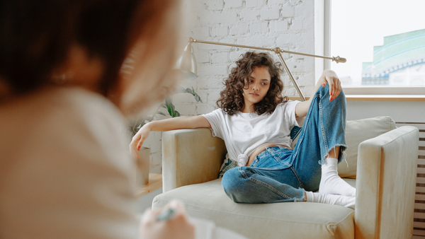 Image of someone sitting on a chair during an appointment in a therapist's office