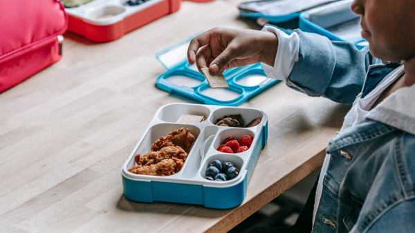 A closeup of a kid eating a school lunch 