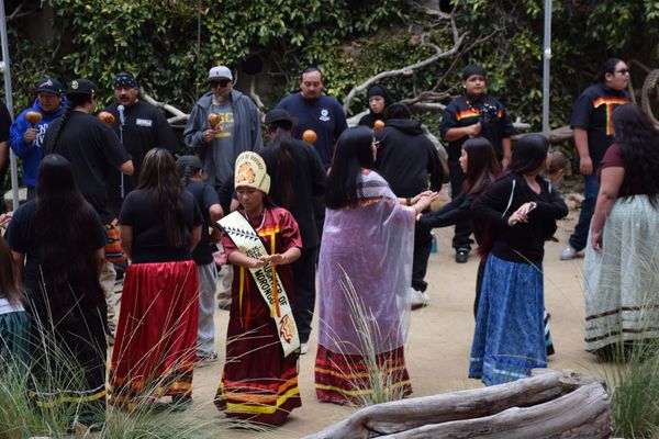 people dance, sing and shake rattles at an outdoor event