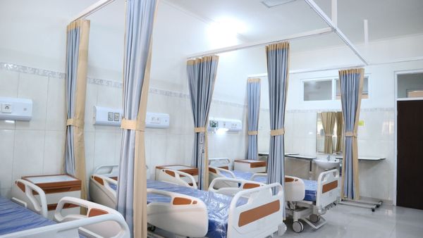 Empty white and brown hospital beds.