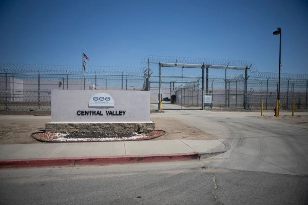 The outside of a prison with razor wire, tall fencing and aisng that says GEO Central Valley