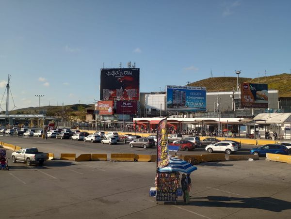 A snack stand is in front of a line of cars waiting to cross through booths