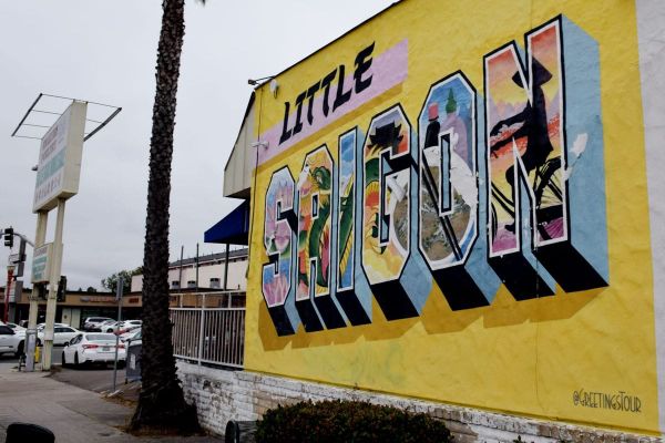 A photo of a mural with a yellow mural that says "Little saigon" with colorful images painted within each letter