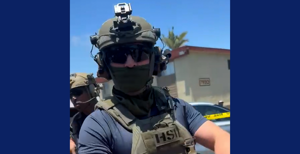 A man with a green helmet and dark face mask and sunglasses 