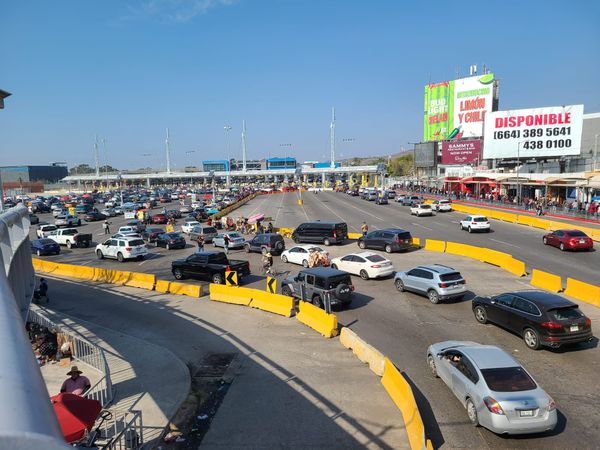 yellow barricades separate cars leading up to customs booths