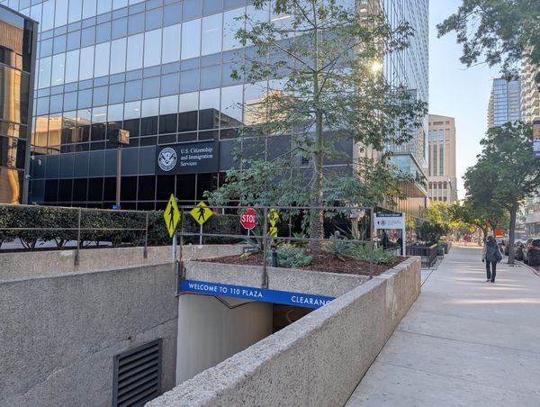 A building with lots of windows and a sign that says U.S. Citizenship and Immigration Services
