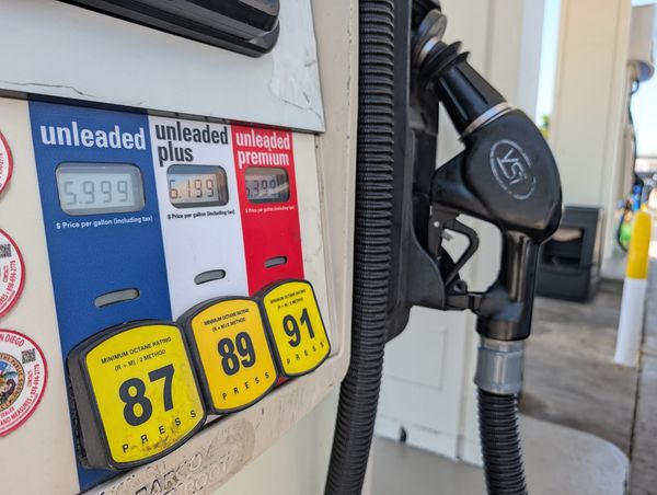 a gas pump with unleaded, unleaded plus and unleaded premium fuel in blue white a and red