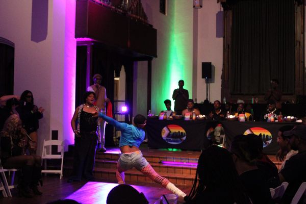 A person wearing blue and sunglasses dances