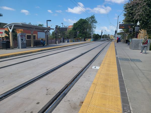 Empty trolley tracks with a couple of people waiting on each side