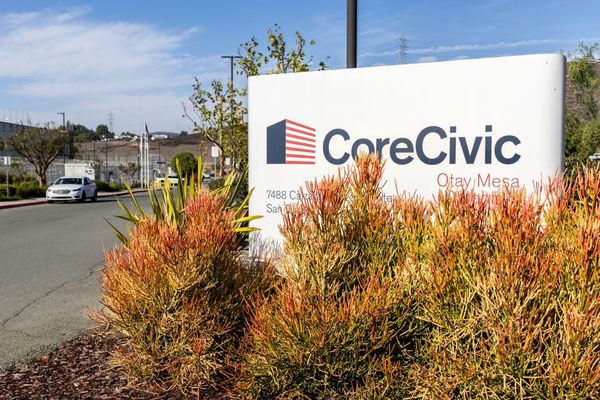 A sign that says CoreCivic next to a prison building