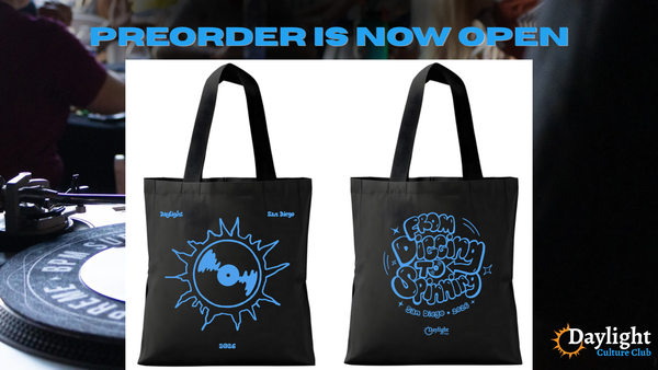 Picture of a DJ booth with images of a black tote bag with blue design that says "Daylight San Diego" with a record on one side, and "From digging to spinning" on the other