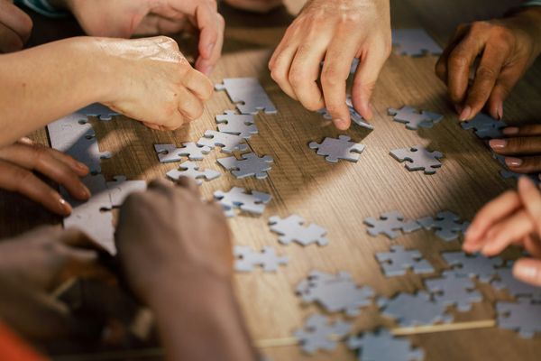 Multiple people making a puzzle together