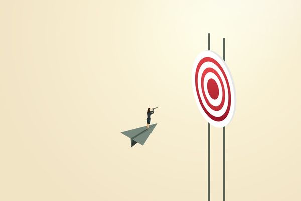 A person riding a paper plane towards a target.