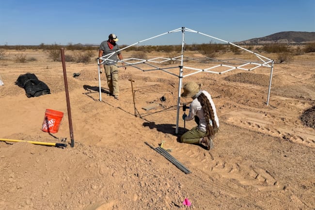 Greg Clark en train d'installer l'armature d'une tente dans le désert de l'Arizona.