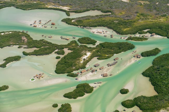 La plage de Chubarna Puerto vue du dessus&nbsp;: eaux turquoises, sable blanc, dunes couvertes de verdure.