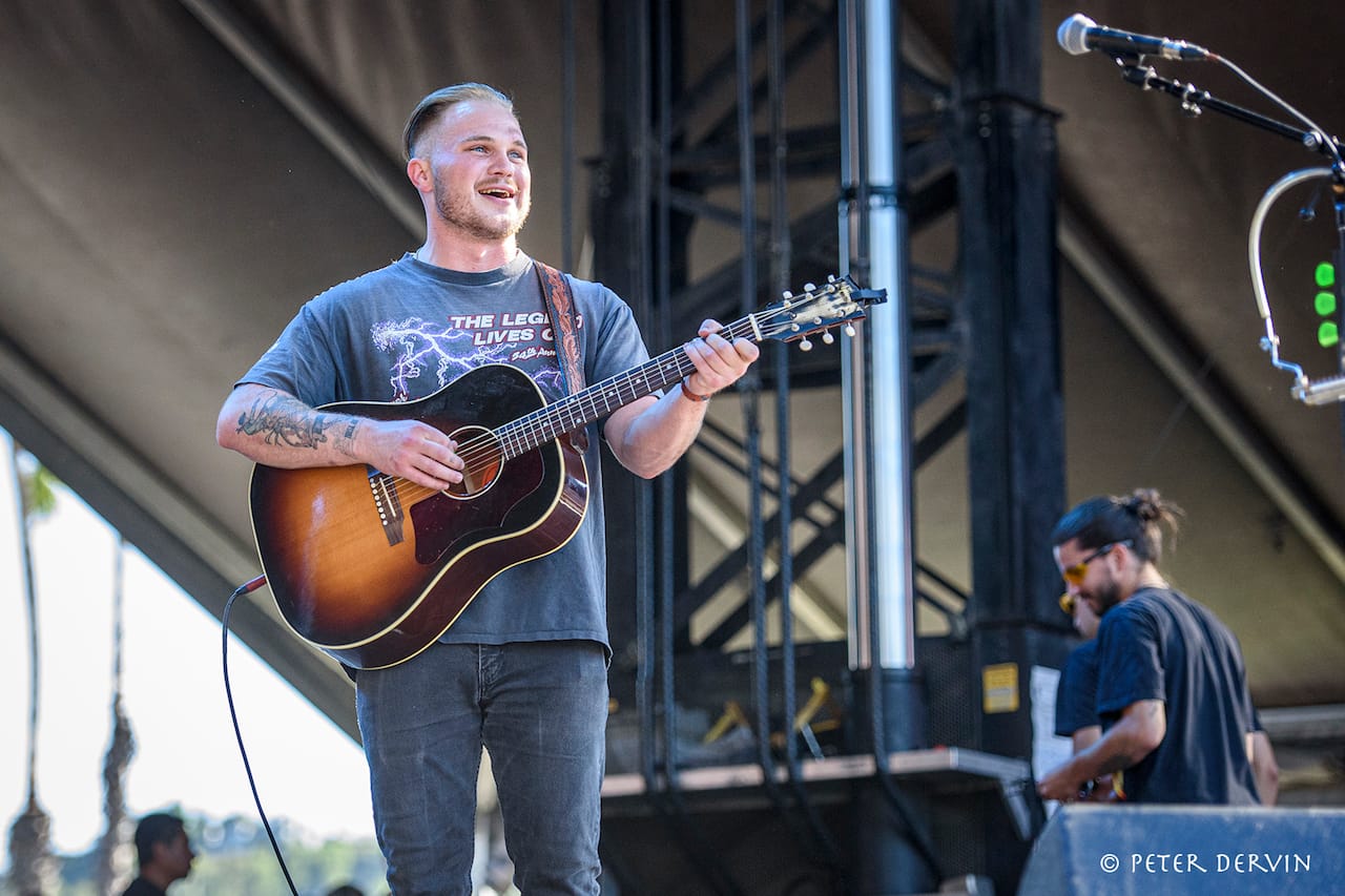 Zach Bryan onstage with an acoustic guitar