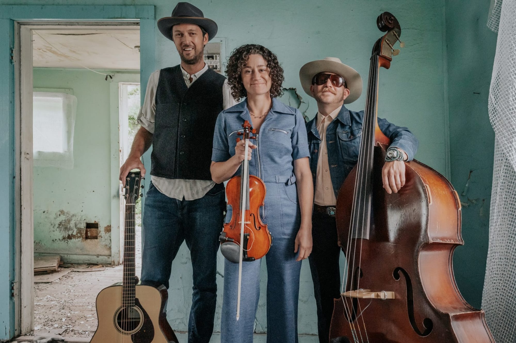 Trio Stillhouse Junkies with instruments in a blue room