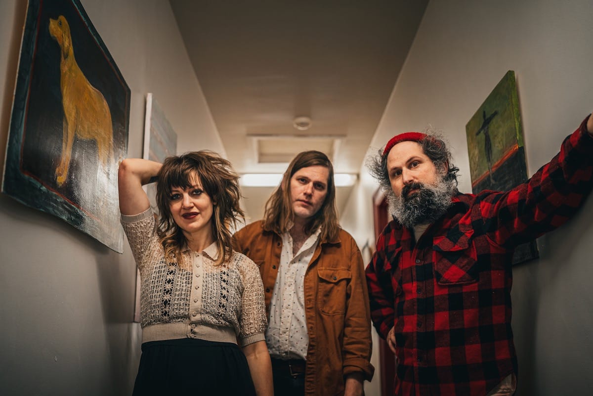 The trio Bonny Light Horseman stands in a hallway