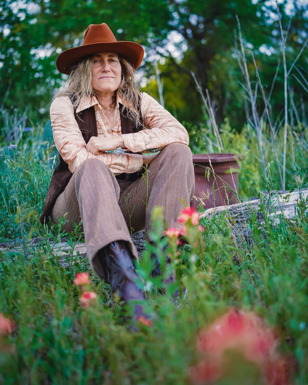 Melissa Carper sits in a grassy field