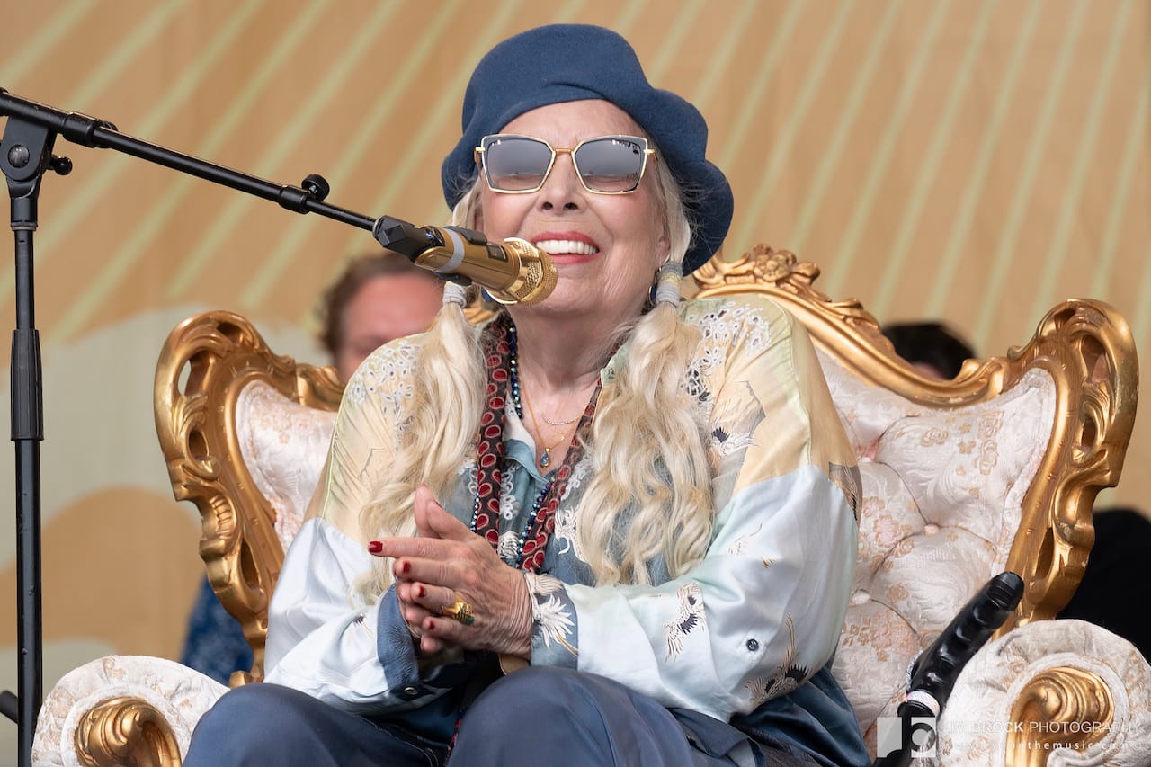 Joni Mitchell seated onstage at Newport Folk Festival