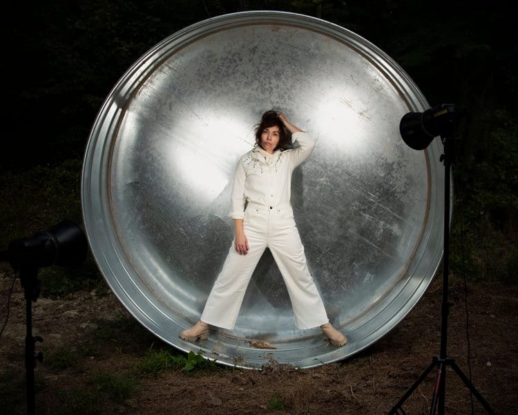 HC McEntire in white suit in a round metal water trough