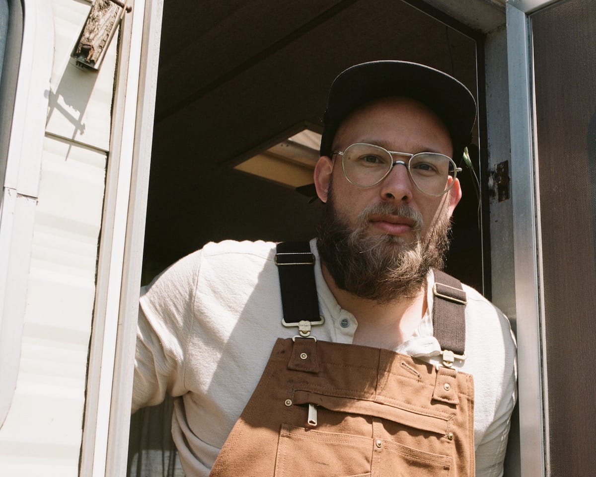 Benjamin Dakota Rogers in the doorway of a white house.
