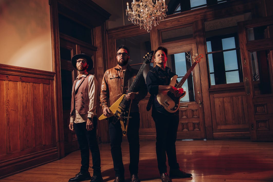 The three members of The Cold Stares in a wood paneled room